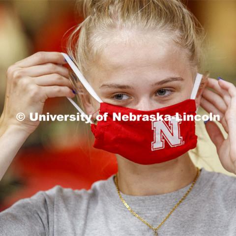 Sophia Merrill, an incoming freshman from Chanhassen, MN, tries on her new N mask. Merrill was shopping in the Nebraska Union bookstore with her family. More than 60,000 face masks are to be distributed to all students, faculty and staff for the fall semester. June 26, 2020. Photo by Craig Chandler / University Communication.