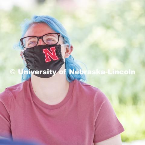 Students socialize on the patio outside the Willa Cather Dining Complex. Photo shoot of students wearing masks and practicing social distancing in dining services in Willa Cather Dining Center. July 1, 2020. Photo by Craig Chandler / University Communication.