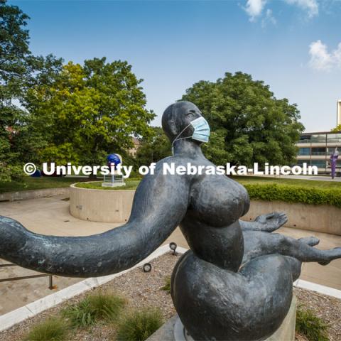 Floating Figure, a sculpture by Gaston Lachaise, is one of many UNL campus sculptures wearing masks. In the background is Untitled by Jun Kaneko also wearing a mask. Mask wearing statues on campus. July 6, 2020. Photo by Craig Chandler / University Communication.