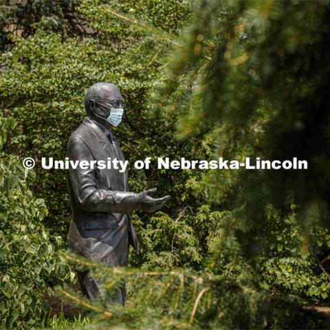 The statue of Clayton Yeutter, one of four Nebraskans who served as U.S. Secretaries of Agriculture, models a mask on the University of Nebraska-Lincoln's East Campus. The sculpture is one of many UNL campus sculptures wearing masks. Mask wearing statues on campus. July 6, 2020. Photo by Craig Chandler / University Communication.