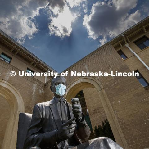 The statue of Clifford Hardin, one of four Nebraskans who served as U.S. Secretaries of Agriculture, models a mask on the University of Nebraska-Lincoln's East Campus. The sculpture is one of many UNL campus sculptures wearing masks. Mask wearing statues on campus. July 6, 2020. Photo by Craig Chandler / University Communication.