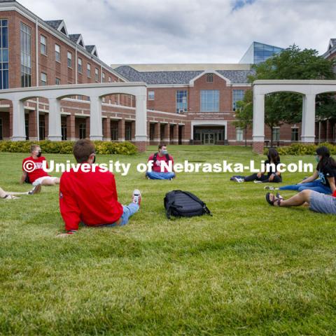 Photo shoot of students on city campus display mask wearing and social distancing. Students lounge on the grass outside Kauffman, all while maintaining a social distance. August 5, 2020. Photo by Craig Chandler / University Communication.