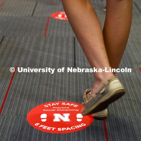 Social distancing stickers are placed on the floors to remind students to keep a distance of six feet apart. Photo shoot of students wearing masks and practicing social distancing. August 11, 2020 Photo by Craig Chandler / University Communication.