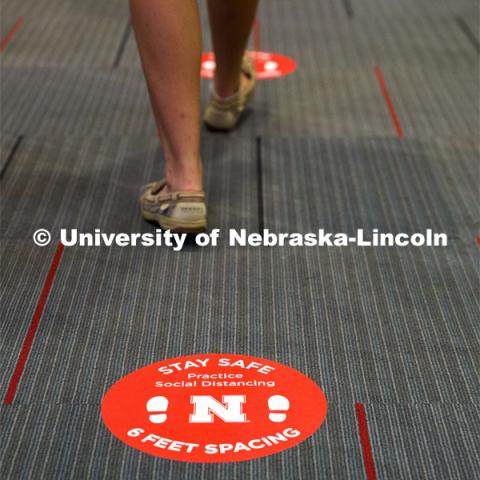 Social distancing stickers are placed on the floors to remind students to keep a distance of six feet apart. Photo shoot of students wearing masks and practicing social distancing. August 11, 2020 Photo by Craig Chandler / University Communication.