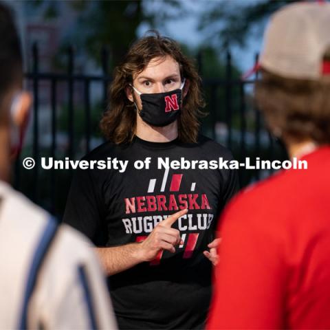 A member of the Nebraska Rugby Club (center) speaks to students during the HuskerMania Masker Singer event at Mabel Lee Fields. August 21, 2020. Photo by Jordan Opp for University Communication.