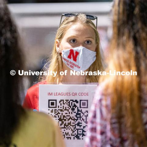 An employee of Nebraska Campus Recreation (center) speaks to students and holds up a QR code for them to scan during the HuskerMania Masker Singer event at Mabel Lee Fields. August 21, 2020. Photo by Jordan Opp for University Communication.