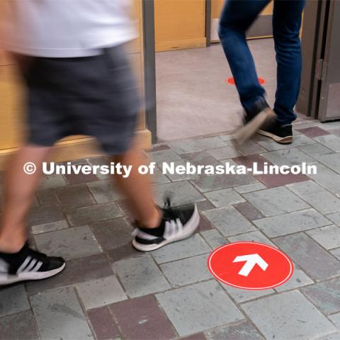 Directional floor arrows keep students at a safe distance. Students walk through the hallways inside of Andersen Hall to get to class during the first day of in-person instruction at the University of Nebraska-Lincoln on Monday, August 24, 2020. Photo by Jordan Opp for University Communication.