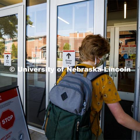 Olivia Benson enters the Carson Center for her class. All the campus doors have been marked to keep the flow of students one way. First day for in-person learning for the fall semester. August 24, 2020. Photo by Craig Chandler / University Communication.