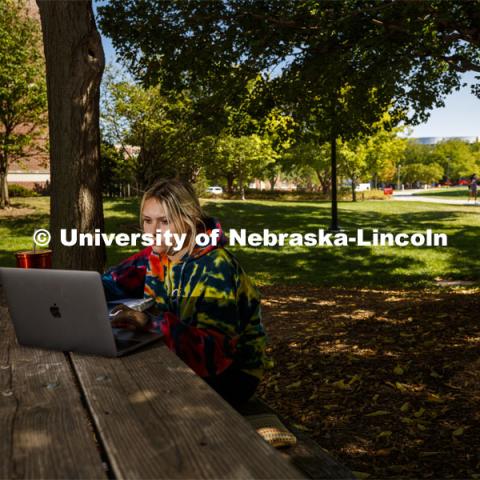 Gabby Huerta zooms her class from a shady bench to the west of Kauffman Academic Residential Center. City Campus. August 31, 2020. Photo by Craig Chandler / University Communication.