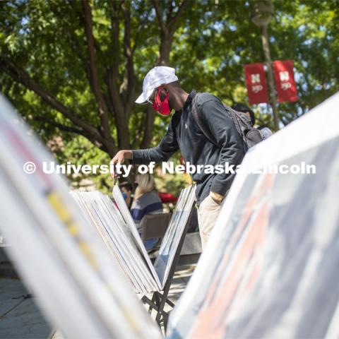 Mohamed Komi looks over posters for sale in front of the Nebraska Union Monday. City Campus. August 31, 2020. Photo by Craig Chandler / University Communication.