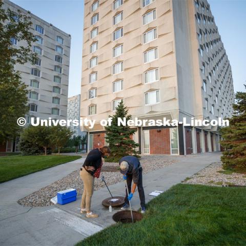 Shannon Bartelt-Hunt observes Spencer Perry, a graduate student in environmental engineering, take a wastewater sample from the sewer flowing from Harper Residence Hall. He and Bartelt-Hunt, professor in civil engineering, are sampling wastewater from UNL residence halls for COVID research. September 24, 2020. Photo by Craig Chandler / University Communication.