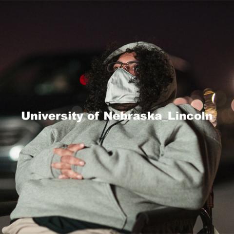 Bundled against the cool evening, James Le Sueur watches his film from a lawn chair near the screen. The northwest corner of Nebraska Innovation Campus was the site for a drive-in movie showing “The Art of Dissent,” a feature documentary film by historian James Le Sueur. The film explores the role of artistic activism during Czechoslovakia’s communist takeover and nonviolent transition from communist power. September 30, 2020. Photo by Craig Chandler / University Communication.