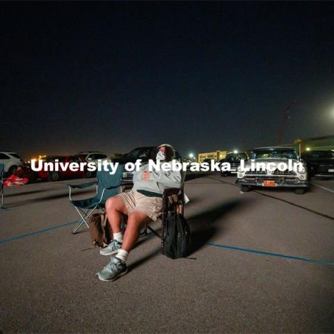 Bundled against the cool evening, James Le Sueur watches his film from a lawn chair near the screen. The northwest corner of Nebraska Innovation Campus was the site for a drive-in movie showing “The Art of Dissent,” a feature documentary film by historian James Le Sueur. The film explores the role of artistic activism during Czechoslovakia’s communist takeover and nonviolent transition from communist power. September 30, 2020. Photo by Craig Chandler / University Communication.