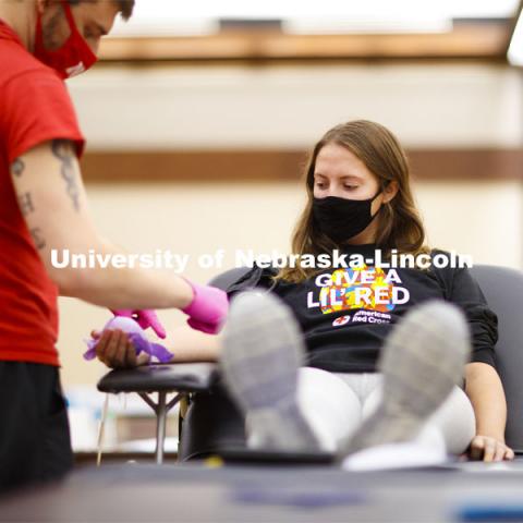 Kacey Heidbrink, a junior from Beatrice, watches as Brandon Thelen preps her arm to donate. Students donate in the Homecoming Blood Drive in the Nebraska Union ballroom on city campus. October 27, 2020. Photo by Craig Chandler / University Communication.