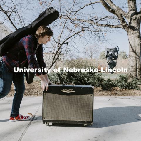 Brock Godown, a freshman from Geneva, rolls his amplifier back to his residence hall following a music class in Westbrook Music Building. November 16, 2020. Photo by Craig Chandler / University Communication.