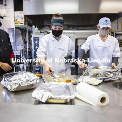 Professor Ajai Ammachathram’s, left, watches as his Catering Management students prepare a wedding feast as the final project for the semester. November 18, 2020. Photo by Craig Chandler / University Communication.