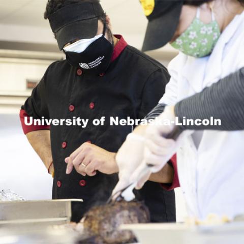 Professor Ajai Ammachathram oversees the carving of the prime rib as his Catering Management students prepare a wedding feast as the final project for the semester. November 18, 2020. Photo by Craig Chandler / University Communication.