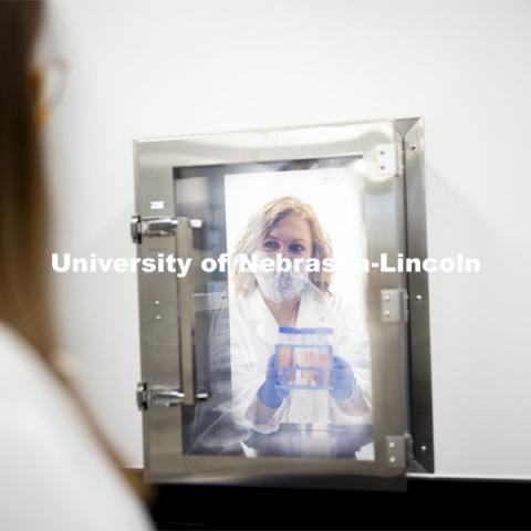 Kristin Beede, research manager with the Department of Food Science and Technology, passes bacterial cultures from the laboratory to the procedure room, where graduate student Ashley Toney awaits them. Nebraska Food for Health Center. November 19, 2020. Photo by Craig Chandler / University Communication.