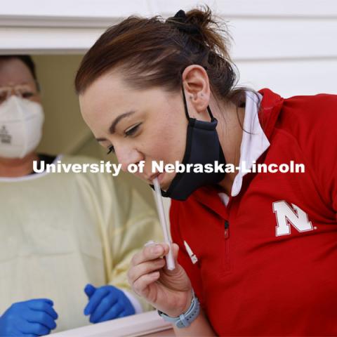 Jessica Calvi, a research assistant professor with the Nebraska Athletic Performance Lab, demonstrates the new saliva-based COVID test as Stephanie Padilla, R.N. watches. In the Spring, students, faculty and staff on campus will be using the test. December 2, 2020. Photo by Craig Chandler / University Communication.