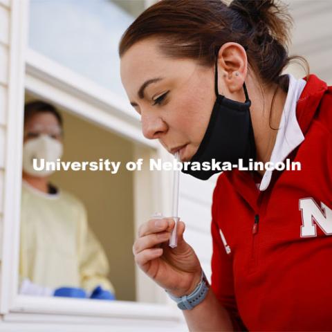 Jessica Calvi, a research assistant professor with the Nebraska Athletic Performance Lab, demonstrates the new saliva-based COVID test as Stephanie Padilla, R.N. watches. In the Spring, students, faculty and staff on campus will be using the test. December 2, 2020. Photo by Craig Chandler / University Communication.