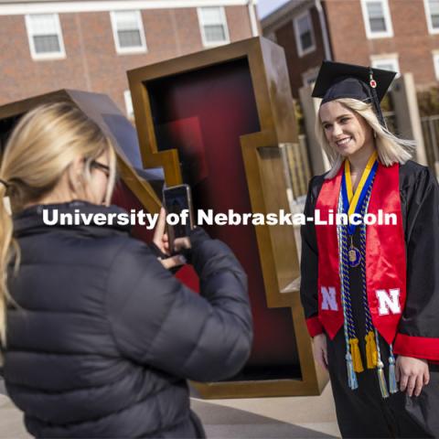 Paige Heitkamp, a senior in Criminal Justice from Sioux Falls is photographed by Jessica Kistaitis in front of The Value of N sculpture at the alumni center. December 8, 2020. Photo by Craig Chandler / University Communication.