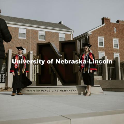 Paige Heitkamp, a senior in Criminal Justice from Sioux Falls, SD, and Tucker Thompson, a senior in secondary education from Highland Park, Illinois, are photographed by Jessica Kistaitis in front of The Value of N sculpture at the alumni center. December 8, 2020. Photo by Craig Chandler / University Communication.