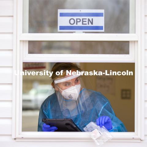 Bria Foley, senior in pre-med and a student worker for the saliva testing, waits for the next walk-up tester Tuesday morning. Saliva testing at East Stadium loop site. January 19, 2021. Photo by Craig Chandler / University Communication.