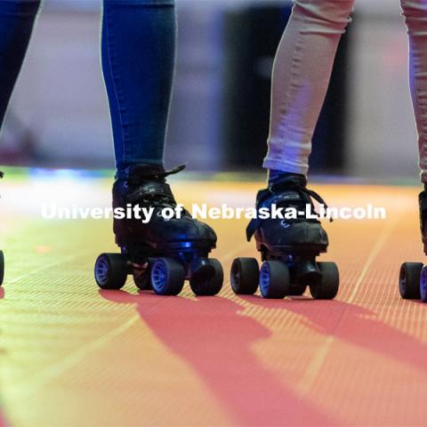 Light shines behind two skaters during the Club 80 Roller Skating Event in the Nebraska Union Ballroom on Friday, February 19, 2021, in Lincoln, Nebraska. Photo by Jordan Opp for University Communication.