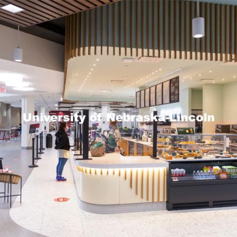 A young woman purchases a coffee at the East Union Starbucks. March 23, 2021. Photo by Craig Chandler / University Communication.