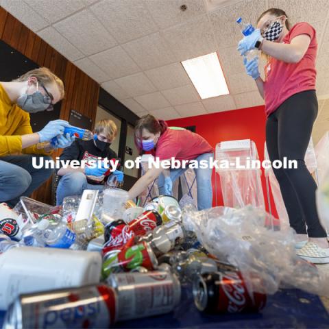 Students check the recycle labels on bottles from Hardin Hall. Environmental Studies Orientation students work on a waste audit of Hardin Hall, Ag Hall, and Filley Hall as part of a class project.  March 24, 2021. Photo by Craig Chandler / University Communication  The waste audit is part of a community engagement assignment for students in Environmental Studies Orientation (ENVR 101). It will entail 11 undergraduate students collecting waste from the new recycling containers on East Campus. After collecting the waste, students will sort the waste into piles to be diverted to landfill and recycling. They will measure and record the weight of the waste. This is the first time the waste stream is being audited using the new recycling containers. The data students collect will be used for a baseline assessment of how the new recycling pilot program is working. 