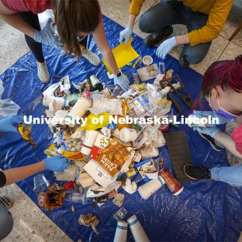 The landfill section of the Hardin Hall recycling stations are sorted by the students. Environmental Studies Orientation students work on a waste audit of Hardin Hall, Ag Hall, and Filley Hall as part of a class project.  March 24, 2021. Photo by Craig Chandler / University Communication  The waste audit is part of a community engagement assignment for students in Environmental Studies Orientation (ENVR 101). It will entail 11 undergraduate students collecting waste from the new recycling containers on East Campus. After collecting the waste, students will sort the waste into piles to be diverted to landfill and recycling. They will measure and record the weight of the waste. This is the first time the waste stream is being audited using the new recycling containers. The data students collect will be used for a baseline assessment of how the new recycling pilot program is working. 