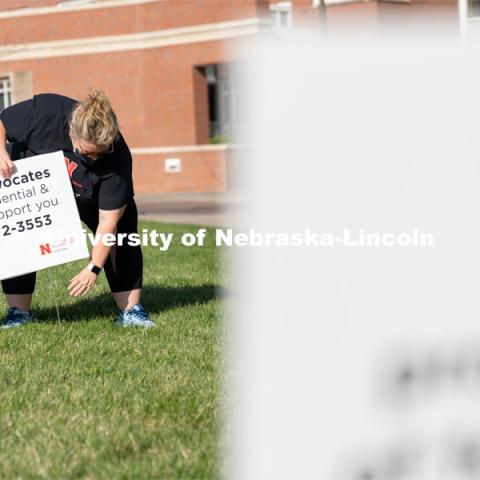 CARE Advocate Melissa Wilkerson places a sign at the Nebraska Union Greenspace. Flags and signs are placed in the Nebraska Union Greenspace to promote Sexual Assault Awareness Month. April 4, 2021. Photo by Jordan Opp for University Communication.