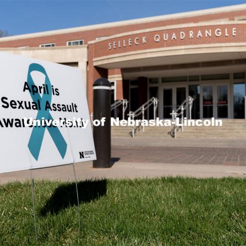A sign recognizing April as sexual assault awareness month is placed on the Nebraska Union Greenspace. Flags and signs are placed in the Nebraska Union Greenspace to promote Sexual Assault Awareness Month. April 4, 2021. Photo by Jordan Opp for University Communication.