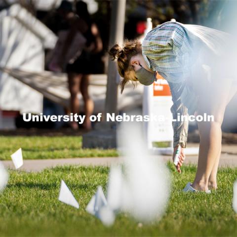 Sophomore psychology major Violet Hudson places flags across the Nebraska Union Greenspace. Flags and signs are placed in the Nebraska Union Greenspace to promote Sexual Assault Awareness Month. April 4, 2021. Photo by Jordan Opp for University Communication.