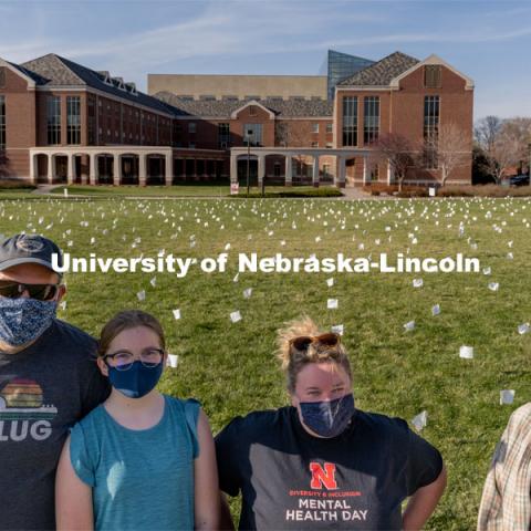 Left to right: Matt Milner, McClellan Milner, Melissa Wilkerson and Violet Hudson pose for a portrait in front of their display at the Nebraska Union Greenspace. Flags and signs are placed in the Nebraska Union Greenspace to promote Sexual Assault Awareness Month. April 4, 2021. Photo by Jordan Opp for University Communication.