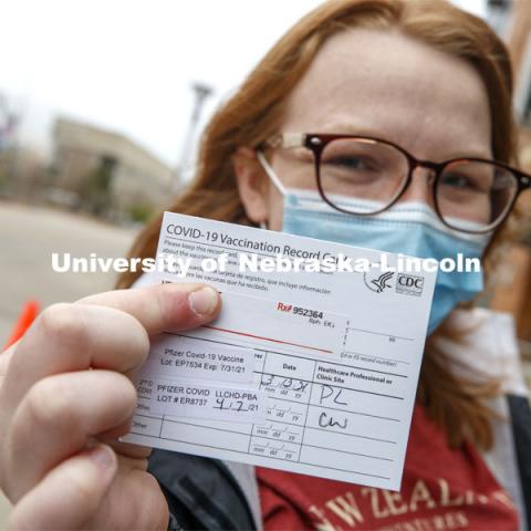 Heather Hunt, senior in Animal Science with the Meat Science option and minoring in Agriculture and Environmental Sciences Communications, shows off her vaccine card after receiving her second shot. More than 150 UNL faculty, staff and student volunteers are helping at the COVID vaccine clinic at Pinnacle Bank Arena this week. April 7, 2021. Photo by Craig Chandler / University Communication.