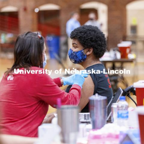 Dameyohn Wood receives his first dose of vaccine during a COVID-19 vaccination clinic April 20 at the Coliseum. Vaccine clinic in the Coliseum with a free food and goodies tent outside. April 20, 2021. Photo by Craig Chandler / University Communication.