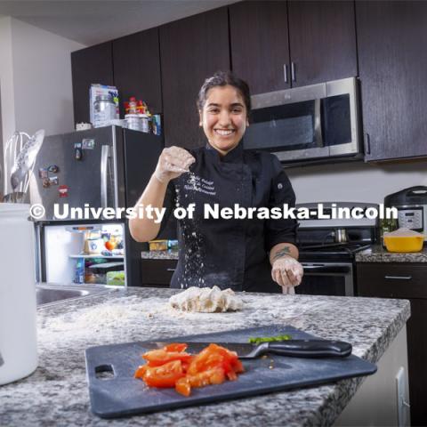 Nidhi Polekar, a triple major in Political Science, English, and Film Studies. She is pictured cooking in her kitchen. ASEM recruitment feature story. May 3, 2021. Photo by Craig Chandler / University Communication.  