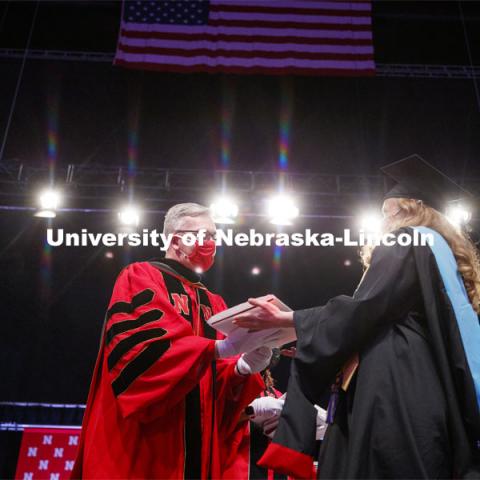Chancellor Ronnie Green wears gloves to hand each graduate including Misty Sue Pocwierz-Gaines their diploma Friday. Graduate Commencement at Pinnacle Bank Arena. May 7, 2021. Photo by Craig Chandler / University Communication.