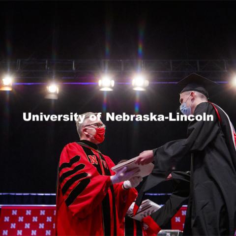 Chancellor Ronnie Green wears gloves to hand each graduate including Misty Sue Pocwierz-Gaines their diploma Friday. Graduate Commencement at Pinnacle Bank Arena. May 7, 2021. Photo by Craig Chandler / University Communication.