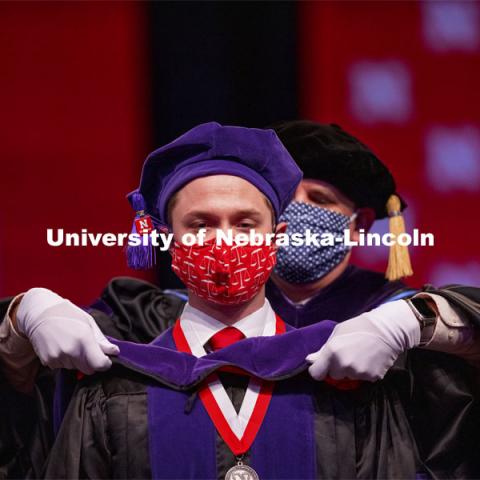 Samuel Baue receives his hood during College of Law Graduation at Pinnacle Bank Arena. May 7, 2021. Photo by Craig Chandler / University Communication.