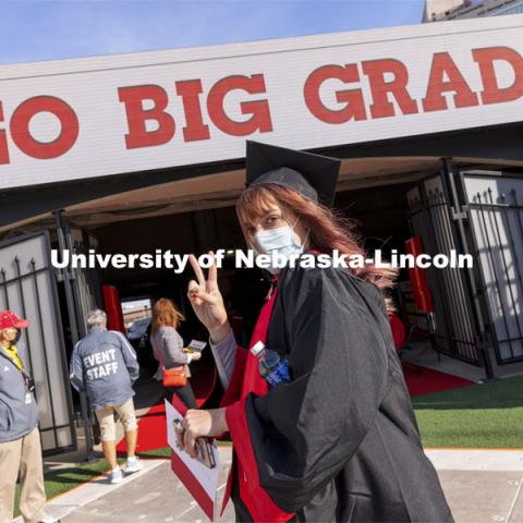 Macy Behrens flashes the peace sign at the UNL Commencement in Memorial Stadium. May 8, 2021. Photo by Craig Chandler / University Communication.