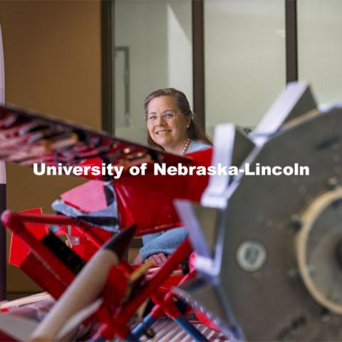 Karen Stelling, is a professor of practice in the engineering college. She is the adviser of the Aerospace Club, which is working on a satellite project with NASA, through a student grant project. She’s also credited with helping develop the leadership curriculum in the College of Engineering. She poses in the lobby of Othmer Hall with a display of Nebraska Engineering aerospace engineering projects. May 20, 2021. Photo by Craig Chandler / University Communication.