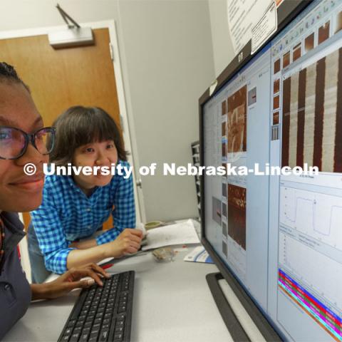 McNair scholar Alyssa Simpson and Professor Xia Hong look over piezoresponse force microscopy images of ferroelectric domains. She is researching ferroelectric domain studies in free-standing PbZr0.2Ti0.8O3 membranes. Physics Summer Research Program. June 22, 2021. Photo by Craig Chandler / University Communication.