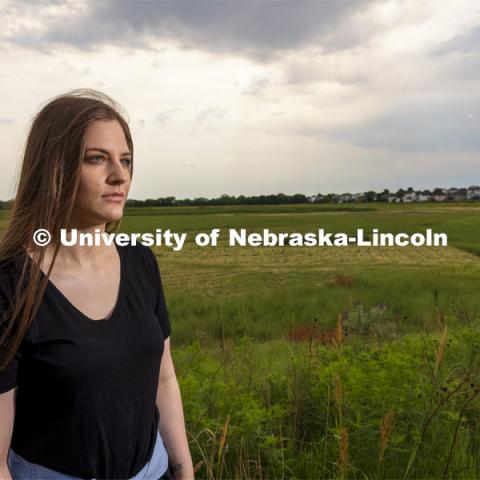 Nicole Fiore, a graduate student in biological sciences, is studying methanogens, a type of methane-producing microorganism, that lives in the wetlands in north Lincoln and could possibly live on Mars. Fiore is pictured by the wetlands behind Cracker Barrel on North 27th Street. June 24, 2021. Photo by Craig Chandler / University Communication.