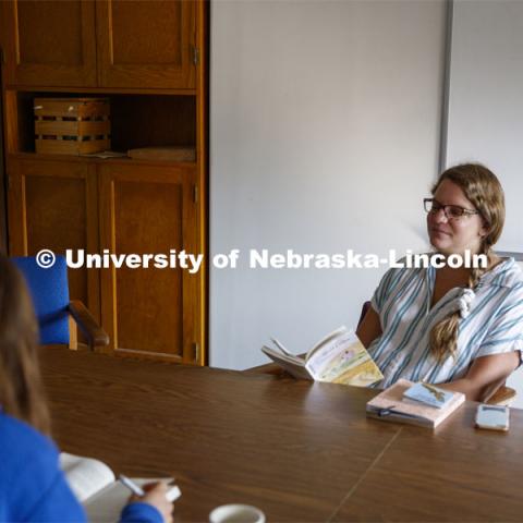 Sarah Hawkinson (blue shirt) and Kaylen Michaelis (tank top) discuss the first few chapters of “O Pioneers!” with their instructor, Emily Rau.Studying Willa Cather at Cedar Point Biological Station near Ogallala, Nebraska. July 19, 2021. Photo by Annie Albin / University Communication