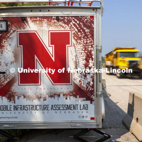 A Nebraska Department of Transportation truck drives past the mobile lab’s equipment trailer. Trucks drove across the bridge singularly and in unison numerous times at varying speeds so the sensors could collect data for each of the runs. NOBL, the Nebraska Outdoor Bridge Lab as part of the College of Engineering is turning two bridge sites (for a total of three bridges) into a national research and educational facility for bridge health and testing. This bridge is across the Platte River on Highway 92 between Yutan and Omaha. August 9, 2021. Photo by Craig Chandler / University Communication.