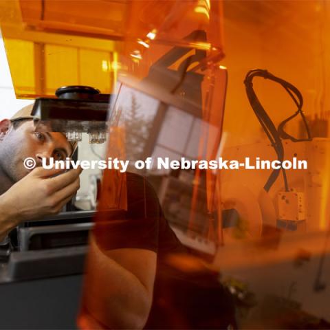 Adan Redwine, a graduate student in Biological Systems Engineering, checks the 3-D printing of his neuron culture system parts for his work in Rebecca Wachs’ lab. Nebraska Innovation Campus. August 10, 2021. Photo by Craig Chandler / University Communication.