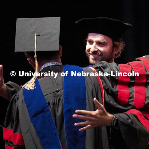 2020 graduate Alex Rosa hugs Professor Rodrigo Werle after Rosa returned to campus to receive his doctoral hood. Summer Graduate Commencement at Pinnacle Bank Arena. August 13, 2021. Photo by Craig Chandler / University Communication.