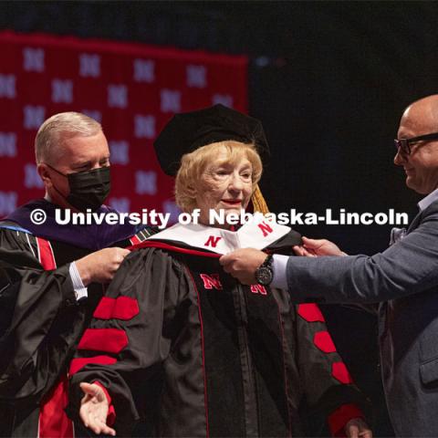 Leta Powell Drake, local television pioneer and Husker alumna, is hooded by NU Regent Tim Clare and Drakes, son, Aaron. Drake was presented with an honorary Doctor of Humane Letters during the undergraduate ceremony. Undergraduate Commencement at Pinnacle Bank Arena. August 14, 2021. Photo by Craig Chandler / University Communication.